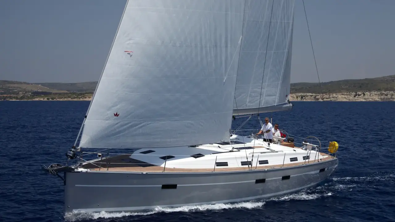 Die **Segelyacht Andromeda** gleitet majestätisch über das tiefblaue Meer, zwei Segel sind gesetzt, zwei Männer am Steuer.