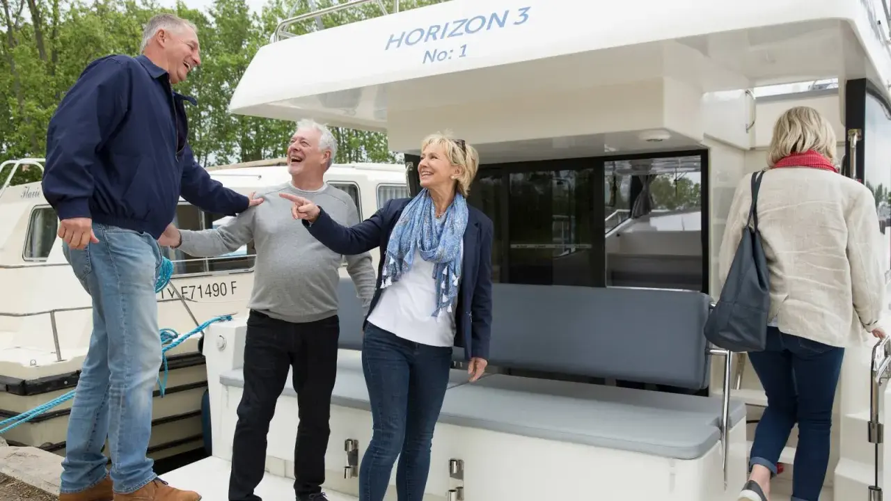 Ein Mann zeigt auf die "HORIZON 3 No: 1", während seine Freunde lachen. Ein schöner Tag für einen Bootsausflug mit aw niemeyer.