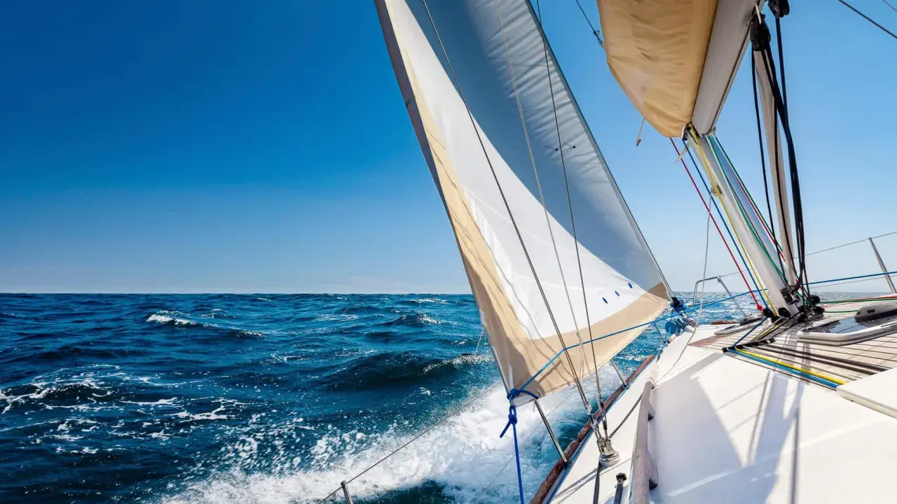 Segelboot gleitet über das Meer, das Takelage schiff ist gut sichtbar, blauer Himmel und Wellen.