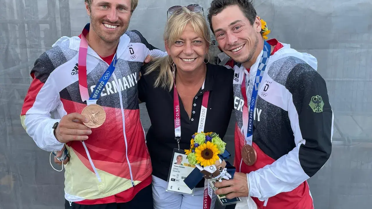 Tatjana Pokorny mit zwei Medaillengewinnern des Team Deutschland bei den Olympischen Spielen in Tokio.