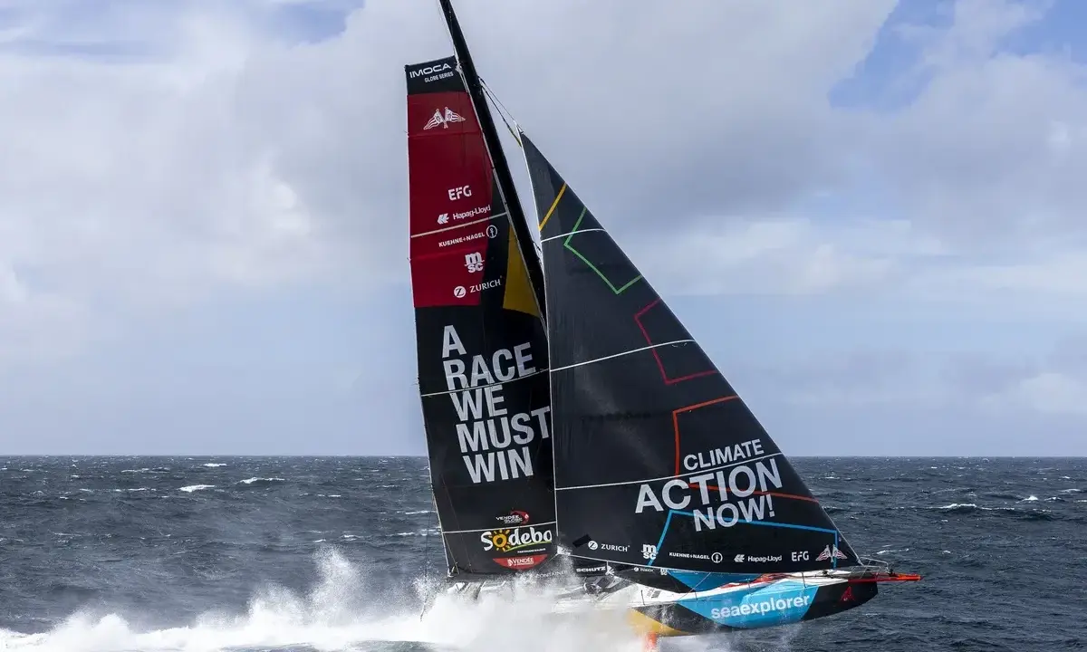 Segelboot mit der Aufschrift "A RACE WE MUST WIN" und "CLIMATE ACTION NOW!" auf dem Weg zum Vendée Globe.