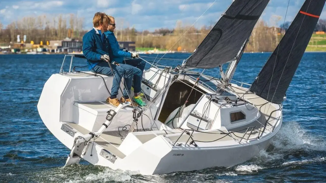 Zwei Männer segeln auf einer SAILART 19 über blaues Wasser.