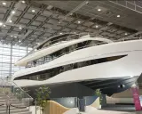 Luxuriöse Yacht, bereit für die boot 2026 Messe. Glänzende weiße Hülle, mehrere Decks und große Fenster.