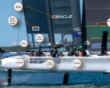 Segelboot der SailGP-Serie mit beschrifteten Teilen wie "Wing", "Driver" und "Strategist". Die Crew ist auf dem Boot zu sehen.