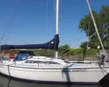 Weiße Segelyacht "Blue Energy" mit blauem Segel, liegend am Steg. Interessante dehler 31 technische daten für Segelfreunde.
