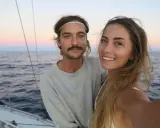 Ein Paar genießt den Sonnenuntergang beim Segeln auf der La Vagabonde.