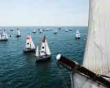 Viele Segelboote auf dem Meer, ein Teil der Segel im Vordergrund. Ein spannender Moment der Golden Globe Race.