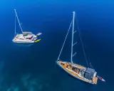 Zwei Segelboote, ein Katamaran und eine Yacht, liegen friedlich auf dem tiefblauen Meer.