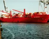 Rotes Containerschiff "Cap Finisterre" im Hafen, beladen mit vielen Containern, Kräne im Hintergrund.