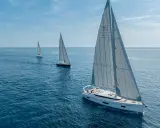 Drei weiße Segelboote segeln auf dem blauen Meer. Die Kosten für ein Segelboot wie dieses sind hoch, aber das Erlebnis unbezahlbar.