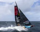 Segelboot mit der Aufschrift "A RACE WE MUST WIN" und "CLIMATE ACTION NOW!" auf dem Weg zum Vendée Globe.