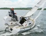 Zwei Segler genießen eine Fahrt auf einer Sailart 20. Das Boot gleitet durch das Wasser, die Segel sind gesetzt.