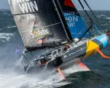 Ein Segelboot kämpft sich durch hohe Wellen, ein Teilnehmer der Segelregatta um die Welt.