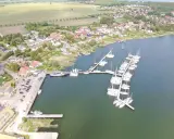 Breege Hafen: Viele Segelboote liegen im Hafen von Breege, umgeben von Häusern und grünen Feldern.