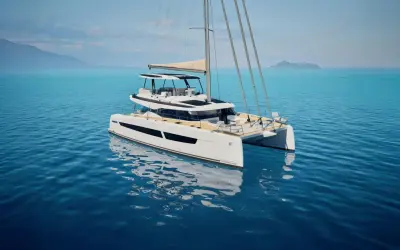 Eine weiße Katamaran-Yacht, eine FOUNTAINE PAJOT, gleitet auf ruhigem, blauem Wasser. Im Hintergrund sind Berge und eine Insel zu sehen.
