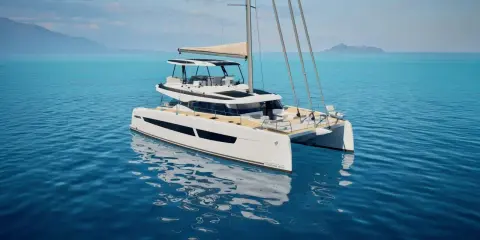 Eine weiße Katamaran-Yacht, eine FOUNTAINE PAJOT, gleitet auf ruhigem, blauem Wasser. Im Hintergrund sind Berge und eine Insel zu sehen.
