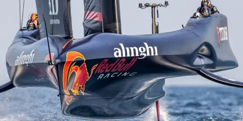 Alinghi Red Bull Racing-Boot hebt ab, die Flügel gleiten über das Wasser.