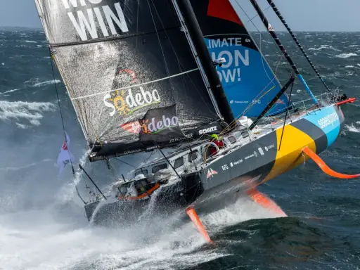 Ein Segelboot kämpft sich durch hohe Wellen, ein Teilnehmer der Segelregatta um die Welt.