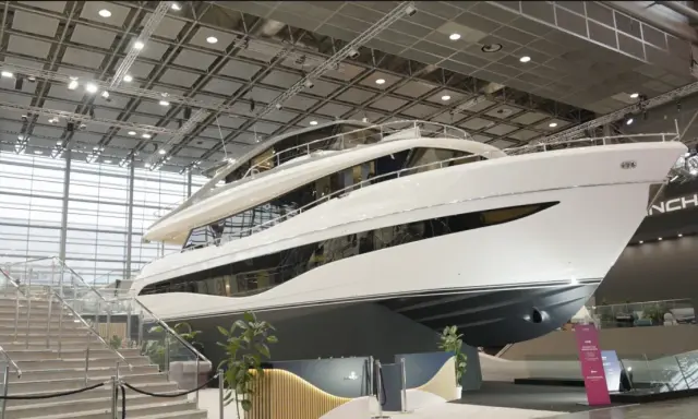 Luxuriöse Yacht, bereit für die boot 2026 Messe. Glänzende weiße Hülle, mehrere Decks und große Fenster.