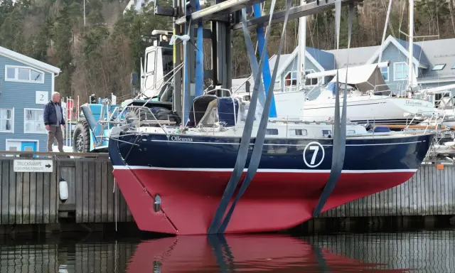 Ein Mann beobachtet, wie ein Rustler 36 namens "Olleanna" mit einem Kran aus dem Wasser gehoben wird.