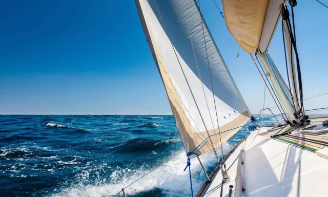 Segelboot gleitet über das Meer, das Takelage schiff ist gut sichtbar, blauer Himmel und Wellen.