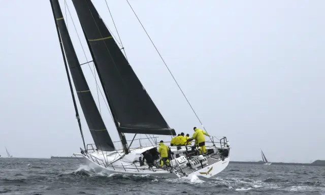 Segelboot mit gelber Crew bei einem spannenden ocean race.