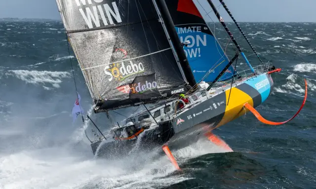 Ein Segelboot kämpft sich durch hohe Wellen, ein Teilnehmer der Segelregatta um die Welt.