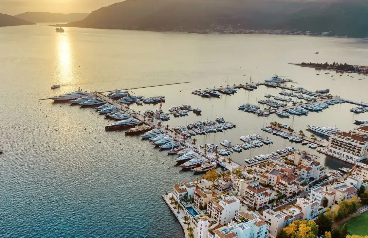 Luxuriöser Porto Hafen mit vielen Yachten und einem Kreuzfahrtschiff im goldenen Abendlicht.