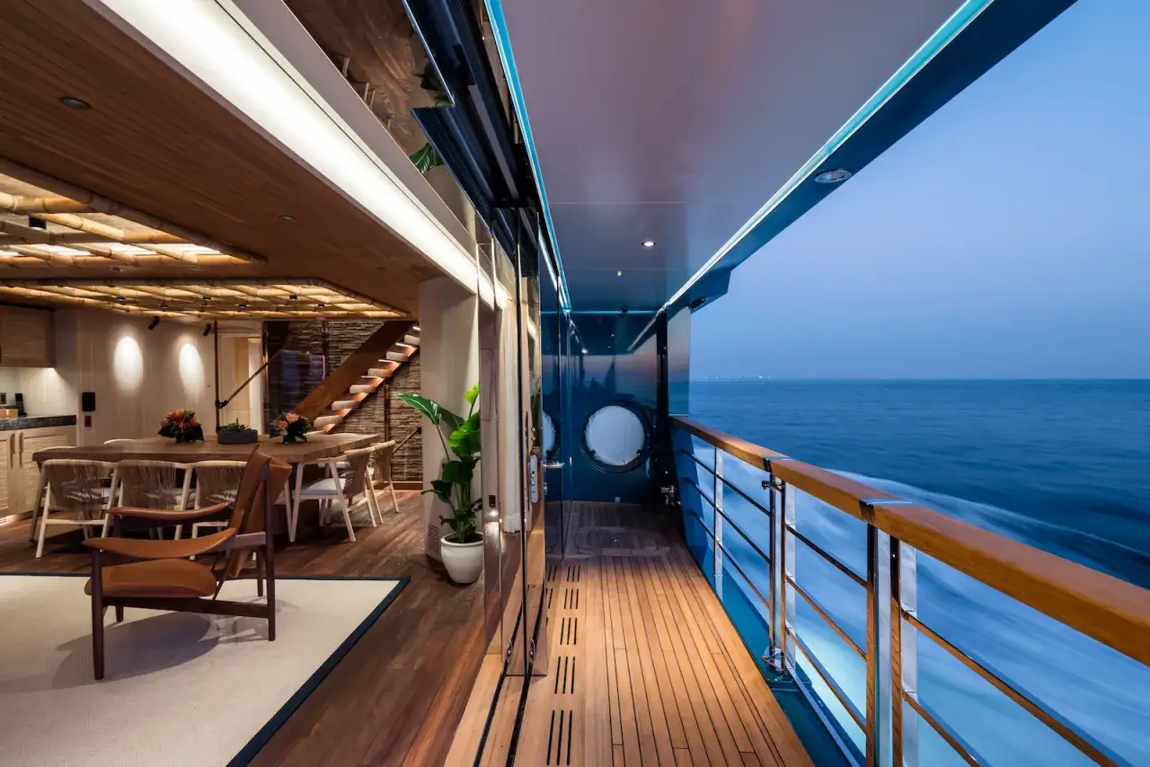 Luxuriöses Interieur und Deck einer Mega-Yacht, mit Blick auf das Meer bei Dämmerung.