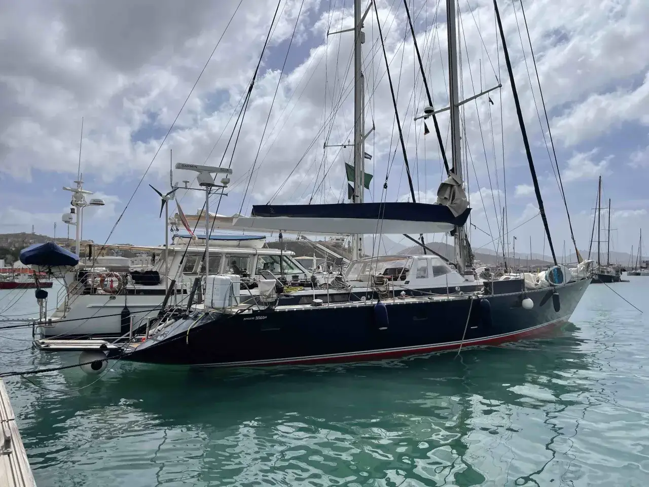 Segelboot im Hafen von Mindelo, Kapverden. Die Sonne spiegelt sich im türkisfarbenen Wasser.