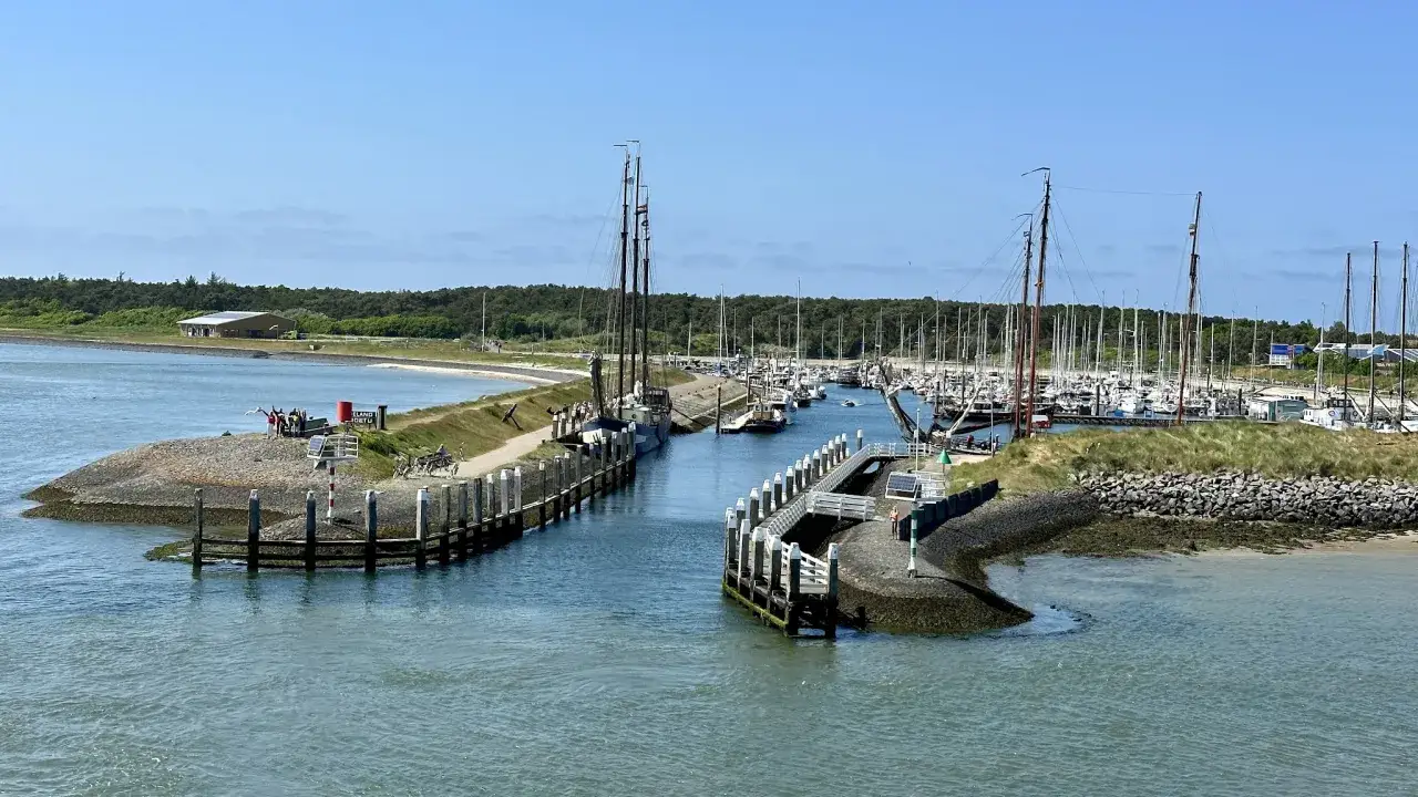 Segelboote im Vlieland Hafen, ein geschäftiger Tag mit vielen Yachten, die auf dem Wasser liegen.