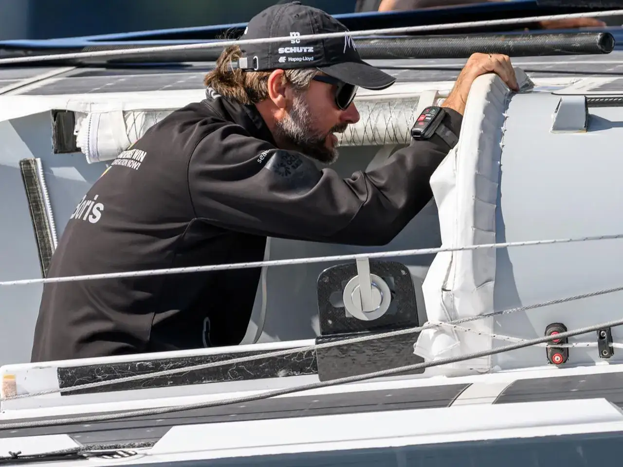 Boris Herrmann, der Segler aus Kiel, auf seinem Boot. Er trägt eine Kappe und Sonnenbrille.