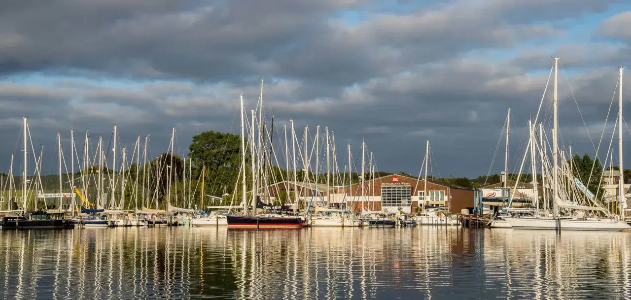Viele Segelboote liegen im Hafen vor Anker. Im Hintergrund ist das