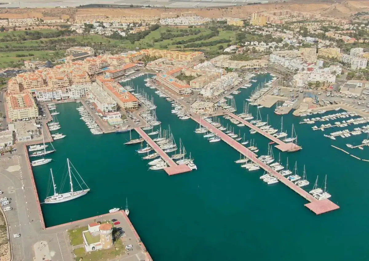 Almerimar Marina: Zahlreiche Segel- und Motoryachten liegen in den t&uuml;rkisfarbenen Gew&auml;ssern vor einer K&uuml;stenstadt mit mediterraner Architektur.