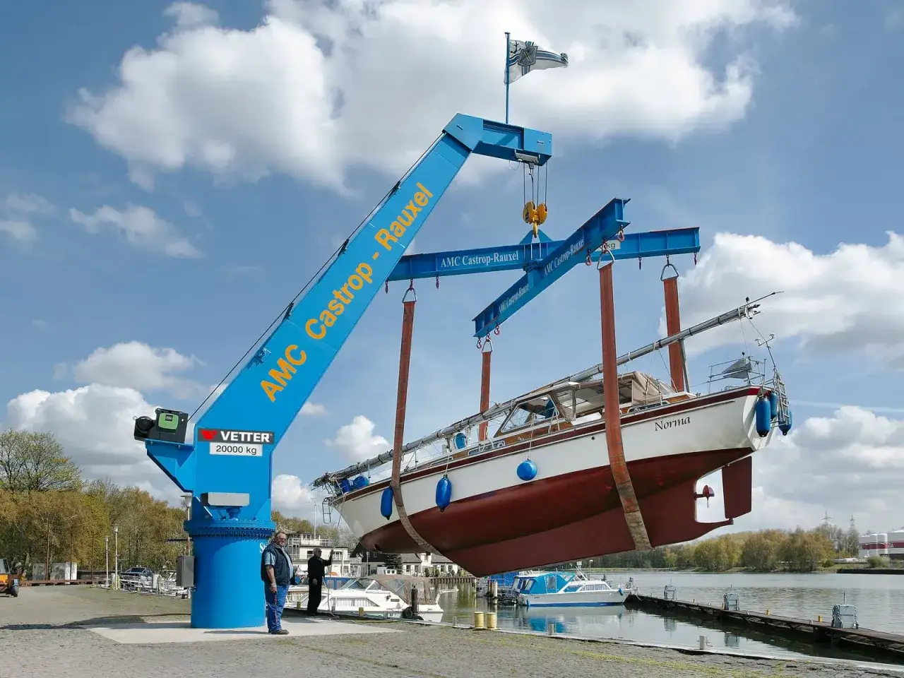 Ein gro&szlig;er blauer Boot kran hebt ein Segelboot namens 