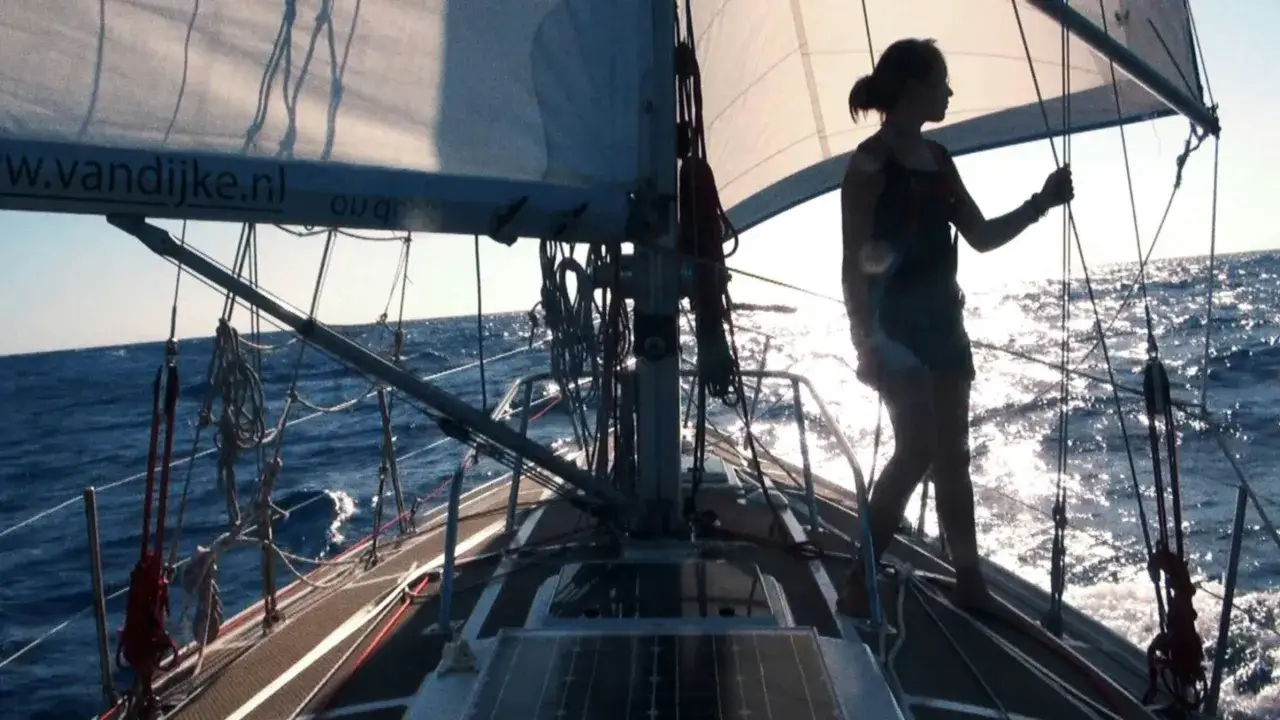 Laura Dekker heute auf ihrem Segelboot, die Sonne spiegelt sich im Meer.