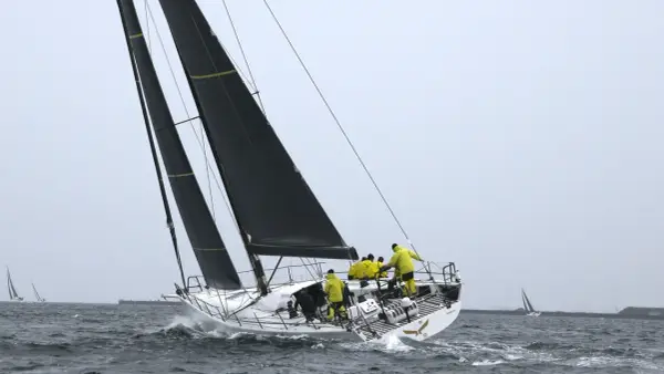 Segelboot mit gelber Crew bei einem spannenden ocean race.