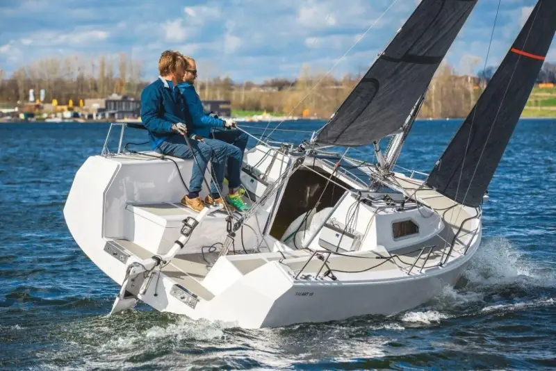 Zwei Männer segeln auf einer SAILART 19 über blaues Wasser.